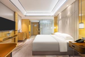 南昌南昌万怡酒店的卧室配有一张白色大床和电视。