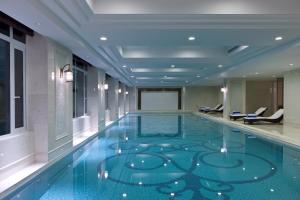 常州Sheraton Changzhou Wujin Hotel的一座建筑物内蓝色地板的游泳池