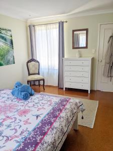 邓斯伯勒Bright & breezy chalet close to town & beach的一间卧室配有一张床、梳妆台和椅子