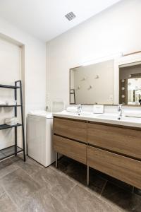 维希La bulle de Vichy Maison 4 pers tout confort的一间带两个盥洗盆和大镜子的浴室