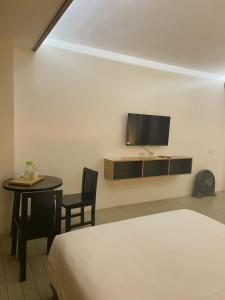 碧瑶Soleo Inn的客房设有1张床、1张桌子和1台电视。