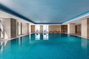 镇江镇江康华汇利喜来登酒店的大楼内的一个蓝色海水游泳池