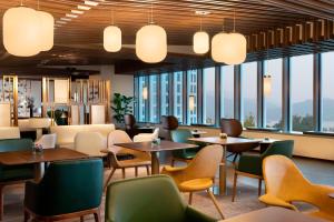 杭州杭州滨江世融艾美酒店的餐厅设有桌椅和大窗户。