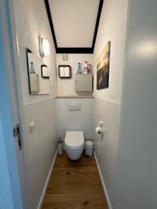 德哈恩Appartement met prachtig polderzicht的走廊上的小浴室设有卫生间