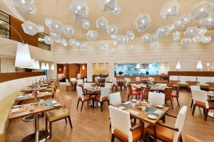 利雅德利雅德奥拉亚万怡酒店的餐厅设有桌椅和吊灯。