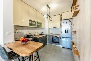 萨格勒布Apartment Saga With Terrace And Parking - Happy Rentals的厨房配有木桌和蓝色冰箱。