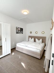 莱塔河畔布鲁克Modernes Haus nähe Parndorf的白色卧室配有白色床单