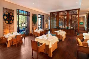 拉萨拉萨瑞吉度假酒店的餐厅设有白色的桌椅和窗户。