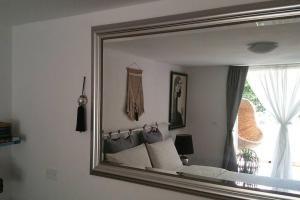 里乔内Cristina’s flat Riccione的卧室内的镜子反射着一张床