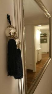 里乔内Cristina’s flat Riccione的挂在墙上的镜子,上面有黑色围巾