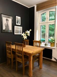 斯扎瓦诺泽德霍Słowackiego No. 5 APARTMENT的一间带木桌和椅子的用餐室