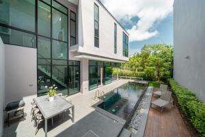 普吉镇Villa Lami - Tropical Modern Loft Phuket with 3BD, private pool, Gym and Sauna的享有带游泳池的外部景致