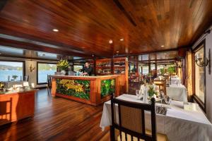 下龙湾Indochina Sails Ha Long Bay Powered by ASTON的一家带酒吧的餐厅,一个男人站在柜台
