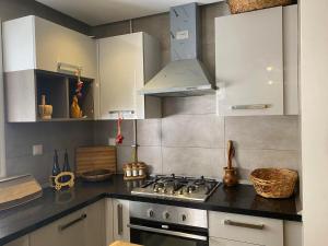 苏塞luxe et confort appartement Sahloul 4的厨房配有白色橱柜和炉灶烤箱。