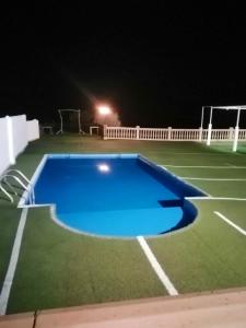 洛哈4 bedrooms villa with private pool and furnished terrace at Loja的享有网球场和游泳池的夜景