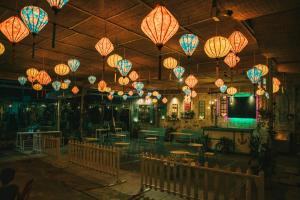罗夷Đại Dương La Gi Homestay & Coffee的餐厅设有挂在天花板上的纸灯