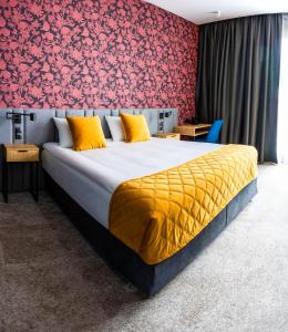 华沙Hotel Sante的一间卧室设有一张红色墙壁的大床
