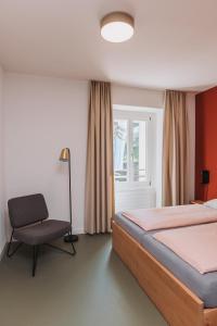 蒙特勒蒙特勒青年旅舍的卧室配有床、椅子和窗户。