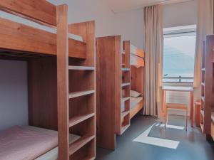 蒙特勒蒙特勒青年旅舍的一间卧室配有双层床、书桌和窗户。