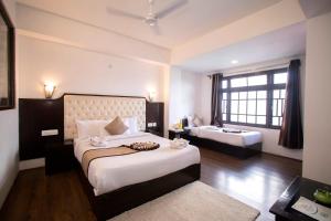 甘托克Tiara Regency Gangtok的一间卧室设有两张床和大窗户