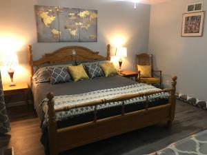 哥伦布Red Brick Country Inn的一间卧室配有一张木床、两张桌子和两盏灯。
