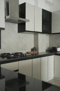 艾藻尔Sewaro Homestay, 2BHK Suite的厨房配有白色橱柜和黑色台面