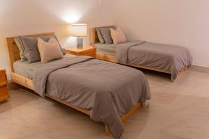 艾藻尔Sewaro Homestay, 2BHK Suite的一间设有两张床和一盏灯的房间