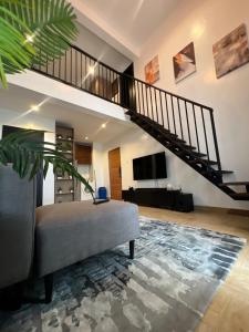 拉各斯COC00N by IVY的一间带楼梯和沙发的客厅