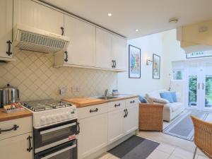 WinkfieldPass the Keys Cosey 3 Sleeper Flat in Winkfield的厨房配有白色橱柜和炉灶烤箱。