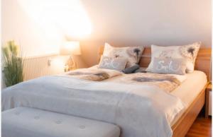 腓特烈港Ferienwohnung Prestige 1的一张配有白色床单和枕头的大床