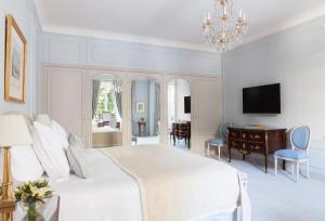 巴黎巴黎布里斯托尔酒店 - 奥克特品质酒店的一间白色卧室,配有床、书桌和电视