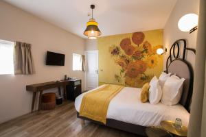 瓦兹河畔欧韦Hotel des Iris的一间卧室配有一张床和一张书桌