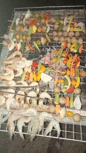Phumĭ Puŏk ChăsMeta Homestay的烤架上有许多不同类型的食物