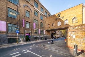 伦敦Crashpads Shoreditch Brick Lane Mini Lofts的砖楼前的一条空的街道