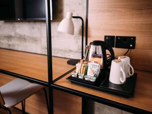 贝尔法斯特宜必思贝尔法斯特市中心酒店的一张桌子,上面有咖啡壶和一盏灯