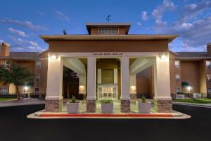 米德瓦尔盐湖城米德维勒/桑迪希尔顿惠庭套房酒店的一座有盆栽门廊的建筑