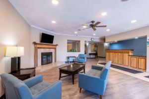 柯克斯维尔Baymont by Wyndham Kirksville University Area的客厅配有蓝色椅子和壁炉