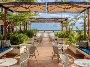 巴拿马城Sofitel Legend Casco Viejo, Panama City的一个带桌椅和遮阳伞的庭院