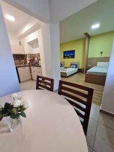 内戈蒂诺Bojana Apartment的一间设有白色桌子的房间和一间卧室