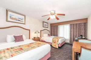 北斯托宁顿Bellissimo Hotel, Trademark by Wyndham Near Foxwoods Casino的酒店客房配有两张床和吊扇。