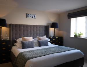 兰厄姆The Harper的一间卧室配有一张带蓝色枕头的大床