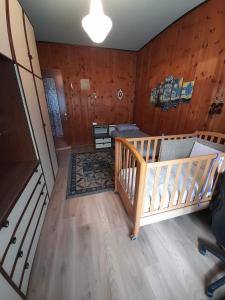 奥斯塔Casa vacanze Gianluca的一间带婴儿床的卧室,位于带木墙的房间内