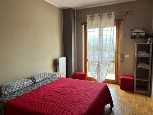 科皮托Dimora del CAMMINATORE的一间卧室设有红色的床和窗户。