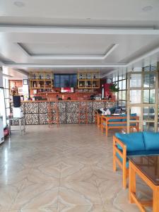 博卡拉Dhikidada Resort的大堂设有桌椅和酒吧。