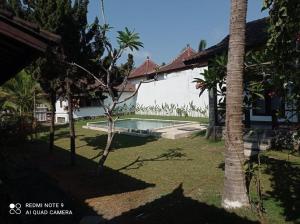 龙目岛库塔Sekar Kuning Bungalows的一个带游泳池和房子的后院