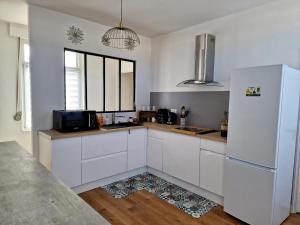 敦刻尔克Appartement Dunkerque的厨房配有白色橱柜和冰箱。