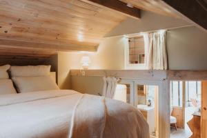 博兰refuges的一间卧室设有一张带木制天花板的大床