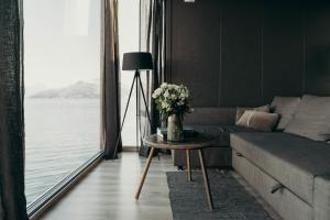 灵塞德Aurora Fjord Cabins的客厅配有沙发和鲜花桌