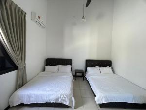 Kampong Bukit KatilTraditional Melaka Homestay with Private Pool的配有白色床单的客房内的两张床