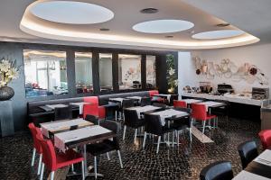 普拉亚达维多利亚Hotel Praia Marina by RIDAN Hotels的用餐室配有桌子和红色椅子